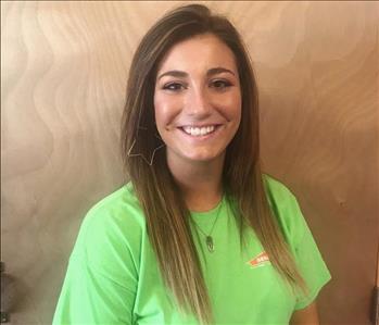 A brown haired girl smiling in a SERVPRO t-shirt