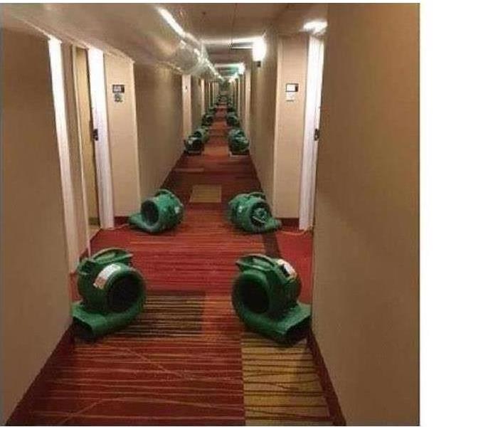 Servpro drying equipment placed down a hotel hall.